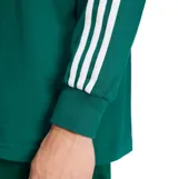 Remera polo de manga larga Adidas en color verde, con cuello y solapa de botones en contraste blanco, y las clásicas tres tiras blancas en las mangas.