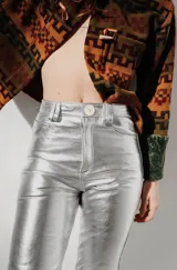 Pantalón de cuero tiro alto y corte recto, color turquesa metalizado, con cierre frontal y botón, bolsillos funcionales.