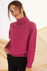 Polera de tejido de punto en color rosa, con cuello alto, mangas largas y puños acanalados.