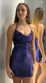 Vestido corto de fiesta en color azul metalizado, con escote drapeado y breteles finos ajustables. Presenta un diseño entallado que se adapta a la silueta.