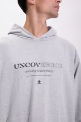 Canguro deportivo gris claro con capucha y bolsillo tipo canguro. Estampado frontal con la frase "Uncovering revealing hidden truths" y un pequeño logo.
