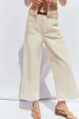 Pantalón de jean color crudo, de tiro alto, corte wide leg cropped y cinturón marrón.