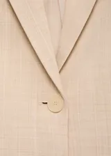 Blazer estructurado de corte recto, color beige, con cuello de solapa, cierre frontal de un botón, bolsillos laterales con solapa y mangas largas con puños abotonados.