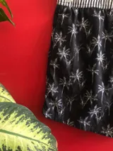 Short de baño negro con estampado de palmeras blancas, cintura elastizada a rayas blancas y negras, cordón ajustable y logo de Reef en el lateral.