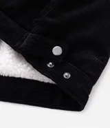 Campera de pana negra con cuello de sherpa blanco, cierre frontal por cremallera y bolsillos delanteros con solapa y botón. Presenta forro interno de sherpa para mayor calidez.