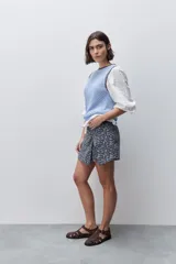 Short cruzado de tiro medio confeccionado en algodón, con diseño que imita una falda en el delantero. Presenta cierre lateral invisible y estampado floral sutil.