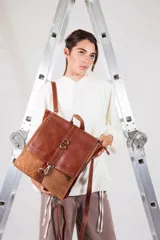 Mochila de cuero vacuno color negro, con tapa de cuero con textura croco color bordó y detalles en blanco. Tiene mosquetón de seguridad exterior, cierre interior, dos bolsillos interiores (uno con cierre y otro para celular), sujetador de llaves, forro completo y tiras ajustables. Se puede usar como mochila o como cartera.