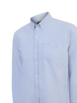 Camisa oxford de manga larga color celeste de la marca RKF, confeccionada en algodón orgánico. Presenta cuello americano con botones, cierre frontal con botones, bolsillo en el pecho con detalle de bordado al tono y calce regular.