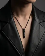 Collar de acero inoxidable en color negro con dije de barra vertical. El dije presenta un grabado en hebreo y una estrella de David en la parte inferior. Incluye cadena de eslabones finos a juego.