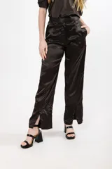 Pantalón negro de seda con tiro alto, corte recto, pinzas en la pretina y tajos en el ruedo.