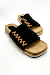 Sandalias bajas de cuero negro con pespuntes en color camel y suela ergonómica forrada en cuero.