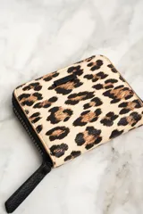 Billetera con cierre de cremallera y estampado animal print de leopardo.