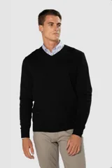 Suéter de tejido fino color azul marino, con cuello en V y manga larga. Presenta un pequeño logo bordado en el pecho.