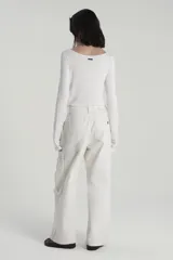 Pantalón jean color crudo, corte cargo, con botamanga ancha y tiro caído. Tiene bolsillos cargo en piernas, lavado stone wash con localizado y desgastes en costuras.