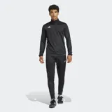 Pantalón de jogging negro Adidas Tiro 25 Essentials con tres rayas blancas en los laterales, corte ajustado y bolsillos con cierre.