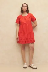 Vestido corto negro con escote redondo, mangas cortas con detalle de calado y falda escalonada con detalle de calado en el ruedo.