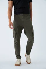 Pantalón cargo de corte slim, color verde militar, con cierre frontal, botón en la cintura, pasacintos y bolsillos laterales con solapa y botones.