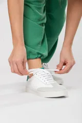 Zapatillas acordonadas de cuero color blanco con puntera de gamuza gris y detalles en verde.
