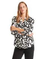 Blusa de gasa estampada en blanco y negro con diseño abstracto. Cuello a la base, escote en V y mangas largas regulables con presilla y botón.