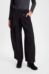 Pantalon de corte amplio y tiro alto con diseño cruzado en la cintura y cierre frontal con boton. Presenta una silueta fluida y relajada.