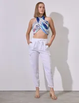 Pantalón jogger blanco de tencel con pretina ancha elastizada, lazo de ajuste, bolsillos delanteros y laterales, y puño elastizado en el ruedo.