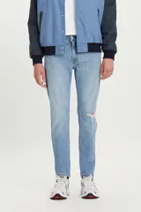 Jean de denim celeste claro con rotura en la rodilla, corte slim fit y tiro medio.