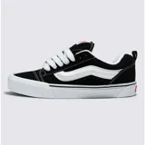 Championes Vans modelo Knu Skool inspirados en los años 90, con diseño de perfil bajo, parte superior de gamuza resistente en color negro, lengüeta y cuello acolchados abultados, y suela de goma blanca con la característica franja lateral Sidestripe en relieve.