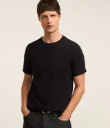 Remera slim de algodón negro con textura acanalada, cuello redondo y mangas cortas.