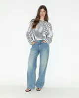 Jeans de tiro medio con corte recto desde la cadera hasta el bajo, de color celeste claro. Diseño clásico de cinco bolsillos con cierre de cremallera y botón metálico.