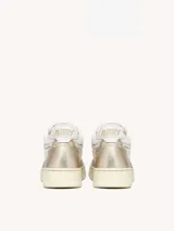 Zapatillas urbanas Autry Open Mid de mujer, inspiradas en el estilo de los años 80. Diseño en cuero color platino y malla color marfil, con cordones de algodón y suela de goma color hueso.