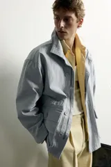 Parka relaxed fit de algodón con efecto lavado, color gris, cuello subido, manga larga y bolsillos de plastrón con solapa en el delantero. Cuenta con cierre frontal de botones y solapa.
