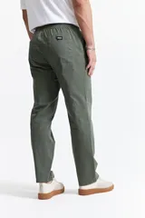 Pantalón de gabardina color azul marino, con diseño de cinco bolsillos, corte relajado, cintura elastizada con cordones ajustables y terminación recta sin puños.