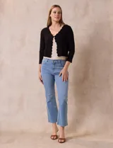 Cardigan tejido en hilado fino color blanco, marca Cable & Gauge. Abertura central con broche interno y terminación ondulada.