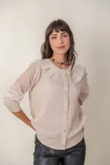 Cárdigan color beige con botones de strass, cuello de tul y mangas de plumeti.