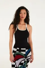 Top tipo musculosa ajustado, color negro, con ribetes blancos en el escote cuadrado y en las sisas.