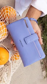 Billetera Lincoln's de mujer en color negro, confeccionada en símil cuero con textura granulada. Presenta un diseño rectangular con cierre de broche, bolsillo frontal con cierre metálico, correa de mano extraíble y logo de la marca grabado en el frente.