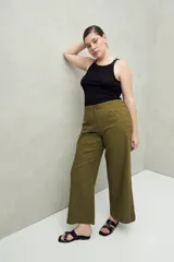 Pantalón de tiro medio con silueta amplia y estructura firme, confeccionado en algodón. Presenta detalle de ojalillos metálicos decorativos en los laterales.