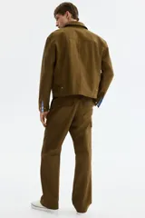 Pantalón cargo de algodón en color verde militar con corte relajado, bolsillos al bies en los laterales, bolsillos de parche con solapa en las piernas y cierre frontal con botón a presión.