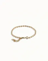 Pulsera de cadena compuesta por pequeños eslabones ovalados de acabado brillante, con cierre de mosquetón y dije colgante pequeño.