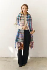 Bufanda larga con estampado a cuadros en tonos celeste, azul, rojo, verde y blanco. Incluye flecos multicolores en los extremos.