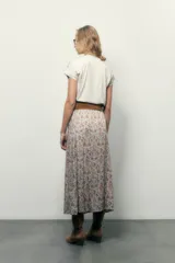 Falda midi estampada con motivos arabescos en tonos beige, celeste y marrón. Presenta tajo frontal y cintura elastizada.