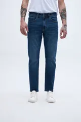 Jean de denim azul oscuro, corte slim fit, entallado en caderas y muslos, ajustado levemente desde la rodilla hasta el tobillo.