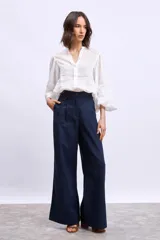 Camisa blanca de mangas largas con apliques de encaje en los puños y en los hombros.