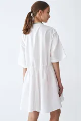 Camisa blanca de poplín de algodón, corte amplio, cuello mao y botones. Tiene recortes con detalles fruncidos en el delantero, espalda y puños.