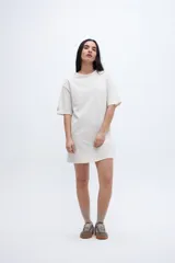 Vestido corto color crema con mangas cortas holgadas y corte recto.