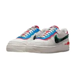 Zapatillas Nike Air Force 1 Shadow color blanco con detalles en rojo, azul y verde. Presentan un diseño deconstruido con superposiciones y detalles a cuadros.