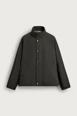 Cazadora regular fit color verde militar de corte clásico, confeccionada en tejido con mezcla de algodón. Cuenta con cuello subido, manga larga raglán, bolsillos de vivo en la cadera y forro interior a contraste con estampado de cuadros. Cierre frontal con cremallera oculta por solapa con botones a presión y bajo ajustable con elásticos ocultos.