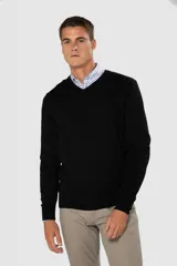 Suéter de tejido fino color azul marino, con cuello en V y manga larga. Presenta un pequeño logo bordado en el pecho.