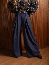 Pantalón palazzo de tiro alto en color azul, con pinzas frontales, bolsillos laterales y cintura elástica.