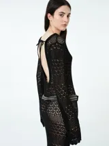 Vestido largo de crochet negro con mangas largas acampanadas y cinturón.